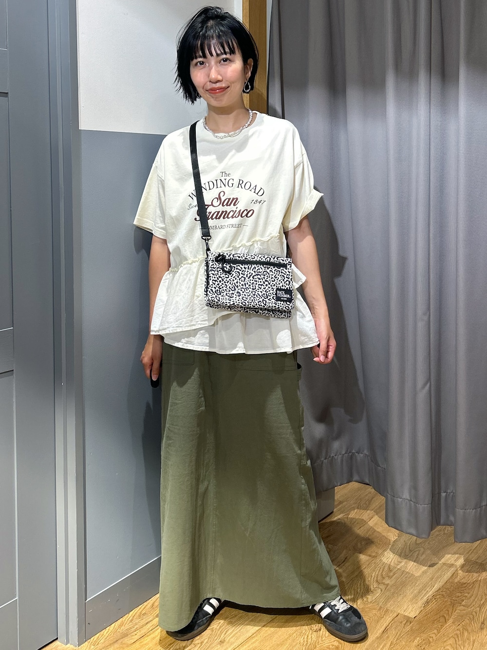 ホワイト系のTシャツ/カットソー、ブラウン系のスカート、ホワイト系のボディバッグ/ウエストポーチを着用したレディースの夏コーディネートの1枚目の写真