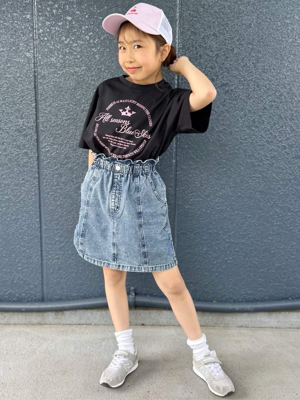 ブラック系のTシャツ/カットソー、ブルー系のデニムスカート、パープル系のキャップを着用したレディースの春コーディネートの1枚目の写真