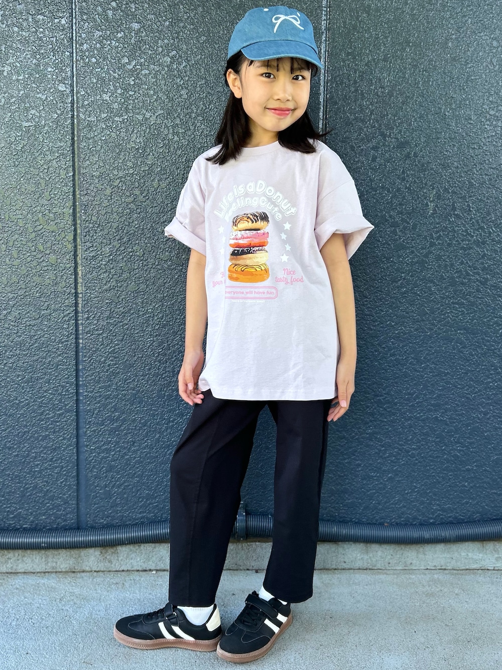 ピンク系のTシャツ/カットソー、ブラック系のその他パンツ、ブルー系のキャップを着用したレディースの春コーディネートの1枚目の写真