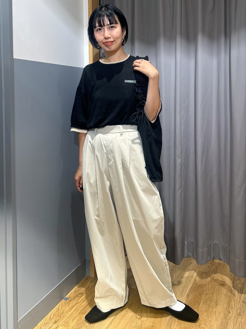 ブラック系のニット/セーター、グレー系のその他パンツ、ブラック系のトートバッグを着用したレディースの夏コーディネートの1枚目の写真