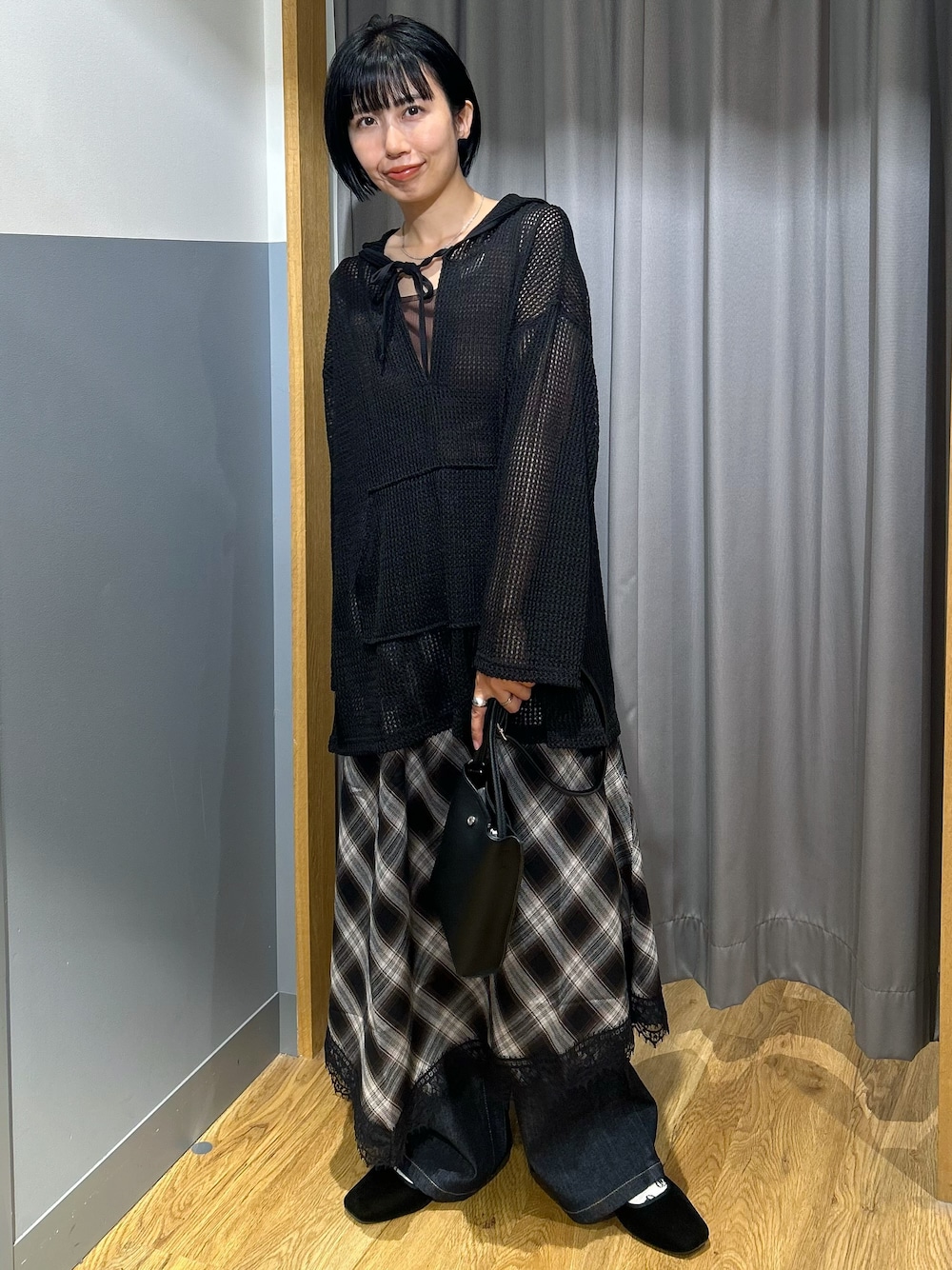 ブラウン系のタンクトップ、ブラック系のTシャツ/カットソー、ブラック系のスカートを着用したレディースの秋コーディネートの1枚目の写真
