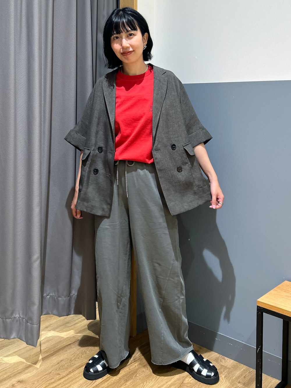 グレー系のテーラードジャケット、レッド系のTシャツ/カットソー、グレー系のその他パンツを着用したレディースの夏コーディネートの1枚目の写真