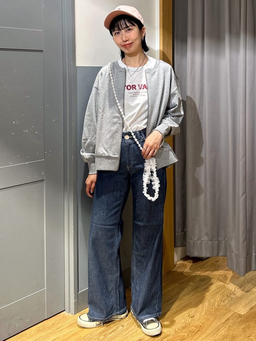 グレー系のTシャツ/カットソー、グレー系のカーディガン/ボレロ、ブルー系のデニムパンツを着用したレディースの春コーディネートの1枚目の写真