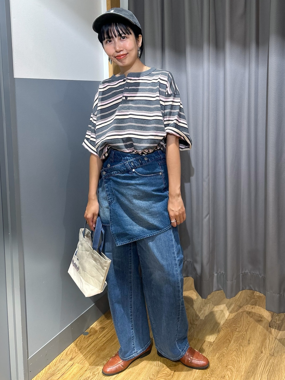 グレー系のTシャツ/カットソー、ブルー系のデニムパンツ、ベージュ系のトートバッグを着用したレディースの夏コーディネートの1枚目の写真