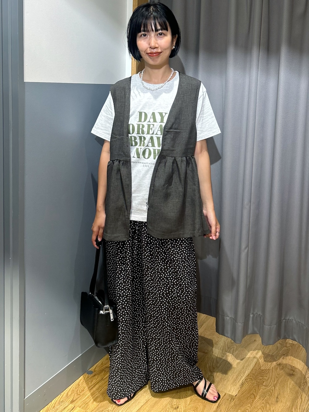 ホワイト系のその他パンツ、グレー系のベスト、ブラック系のショルダーバッグを着用したレディースの夏コーディネートの1枚目の写真