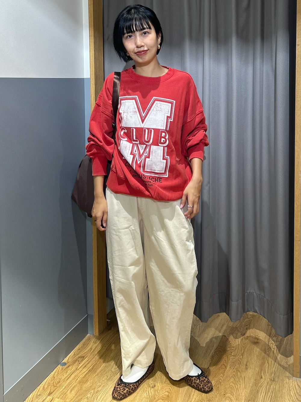 レッド系のスウェット、ホワイト系のその他パンツ、ブラウン系のバックパック/リュックを着用したレディースの秋コーディネートの1枚目の写真