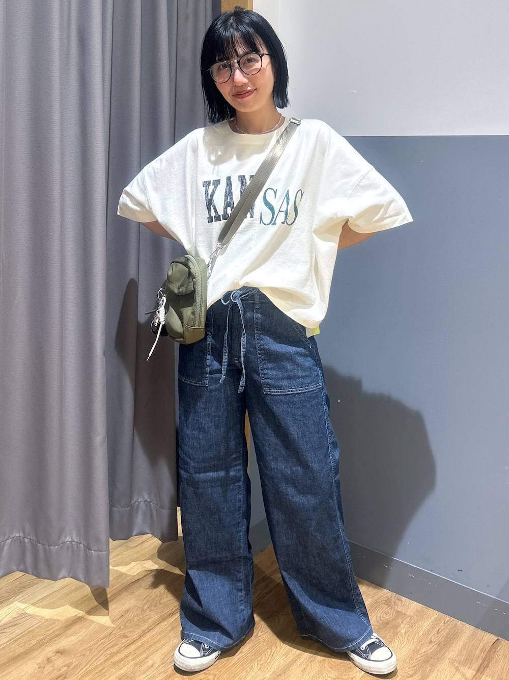ホワイト系のTシャツ/カットソー、ブルー系のデニムパンツ、グリーン系のショルダーバッグを着用したレディースの夏コーディネートの1枚目の写真