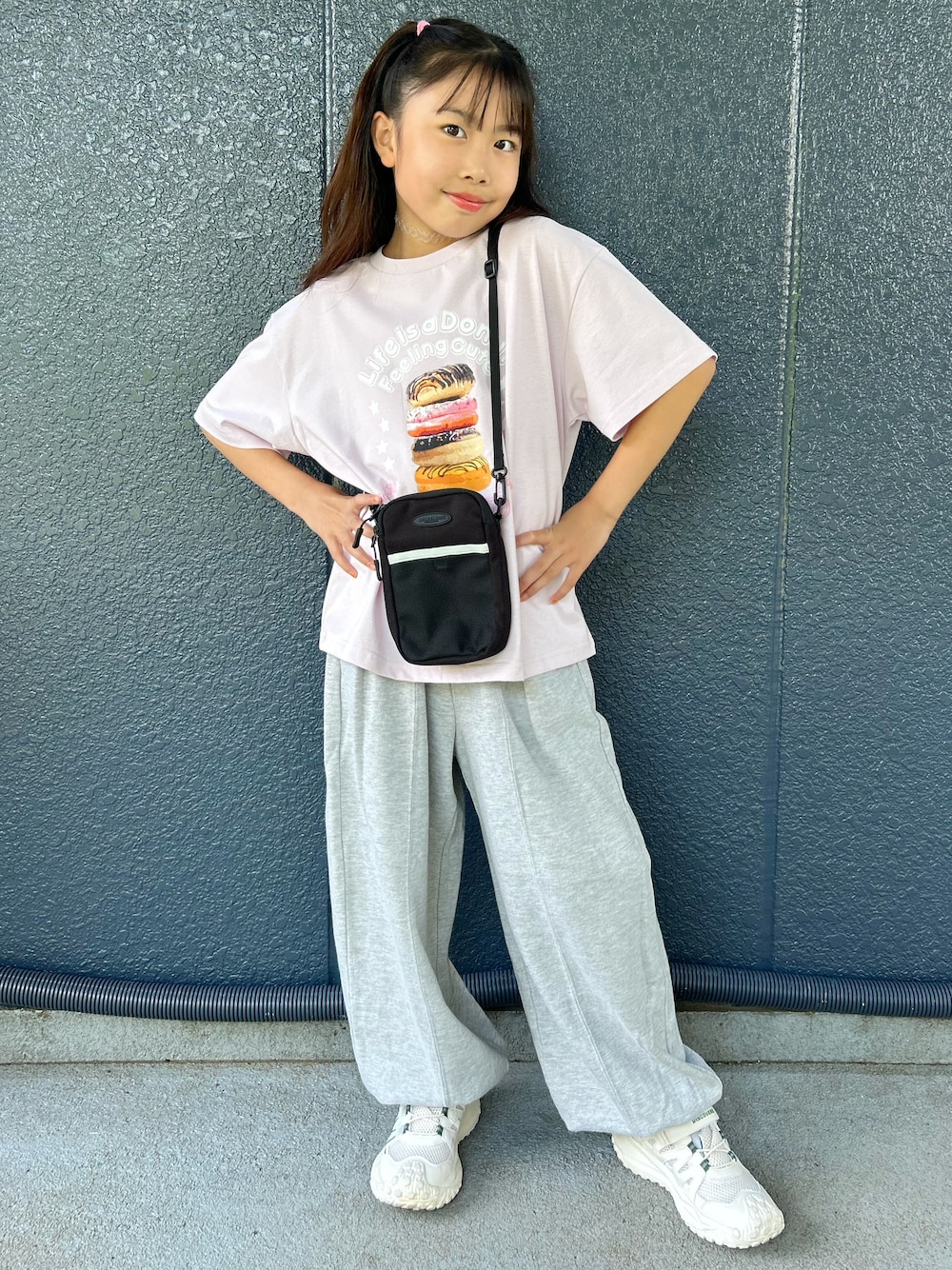 ピンク系のTシャツ/カットソー、グレー系のその他パンツ、ブラック系のショルダーバッグを着用したキッズの夏コーディネートの1枚目の写真