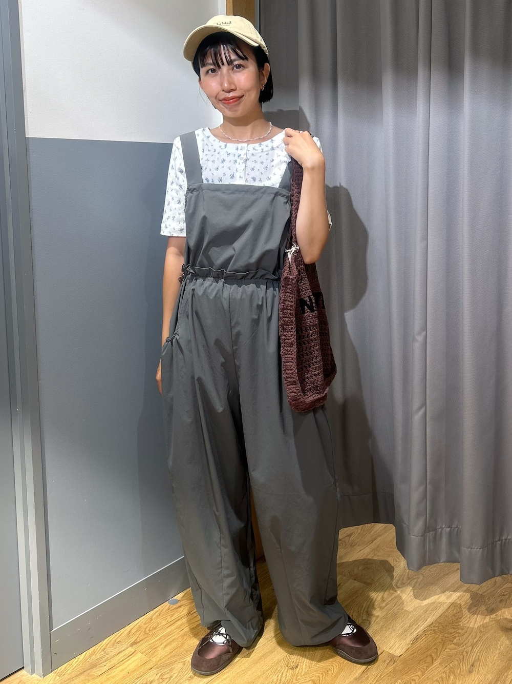 グリーン系のサロペット/オーバーオール、ブルー系のTシャツ/カットソー、ベージュ系のキャップを着用したレディースの夏コーディネートの1枚目の写真