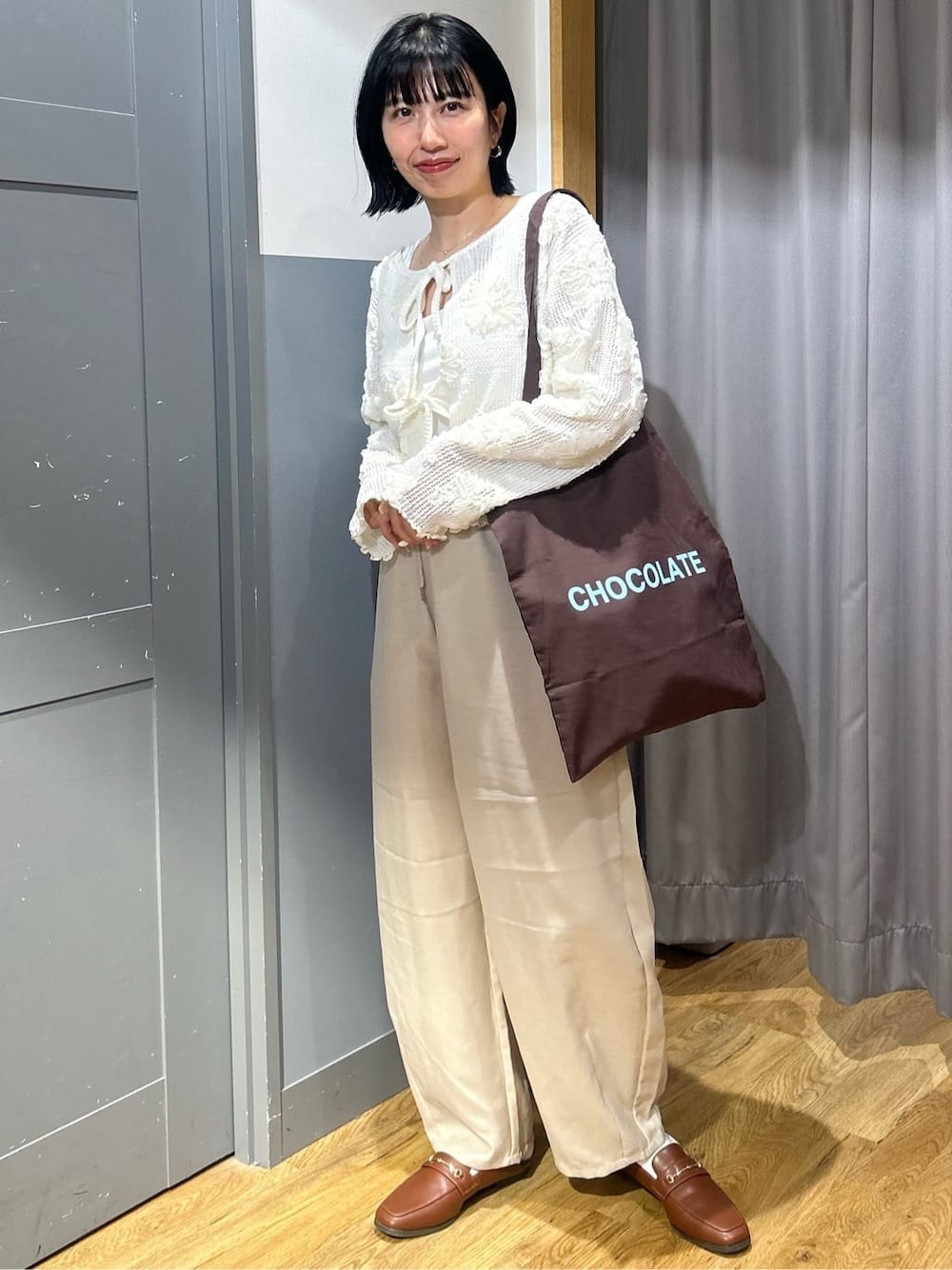 ホワイト系のカーディガン/ボレロ、ホワイト系のタンクトップ、ベージュ系のその他パンツを着用したレディースの春コーディネートの1枚目の写真