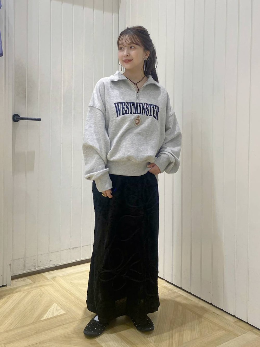 グレー系のスウェット、ブラック系のバレエシューズ、ブラック系のスカートを着用したレディースの秋コーディネートの1枚目の写真