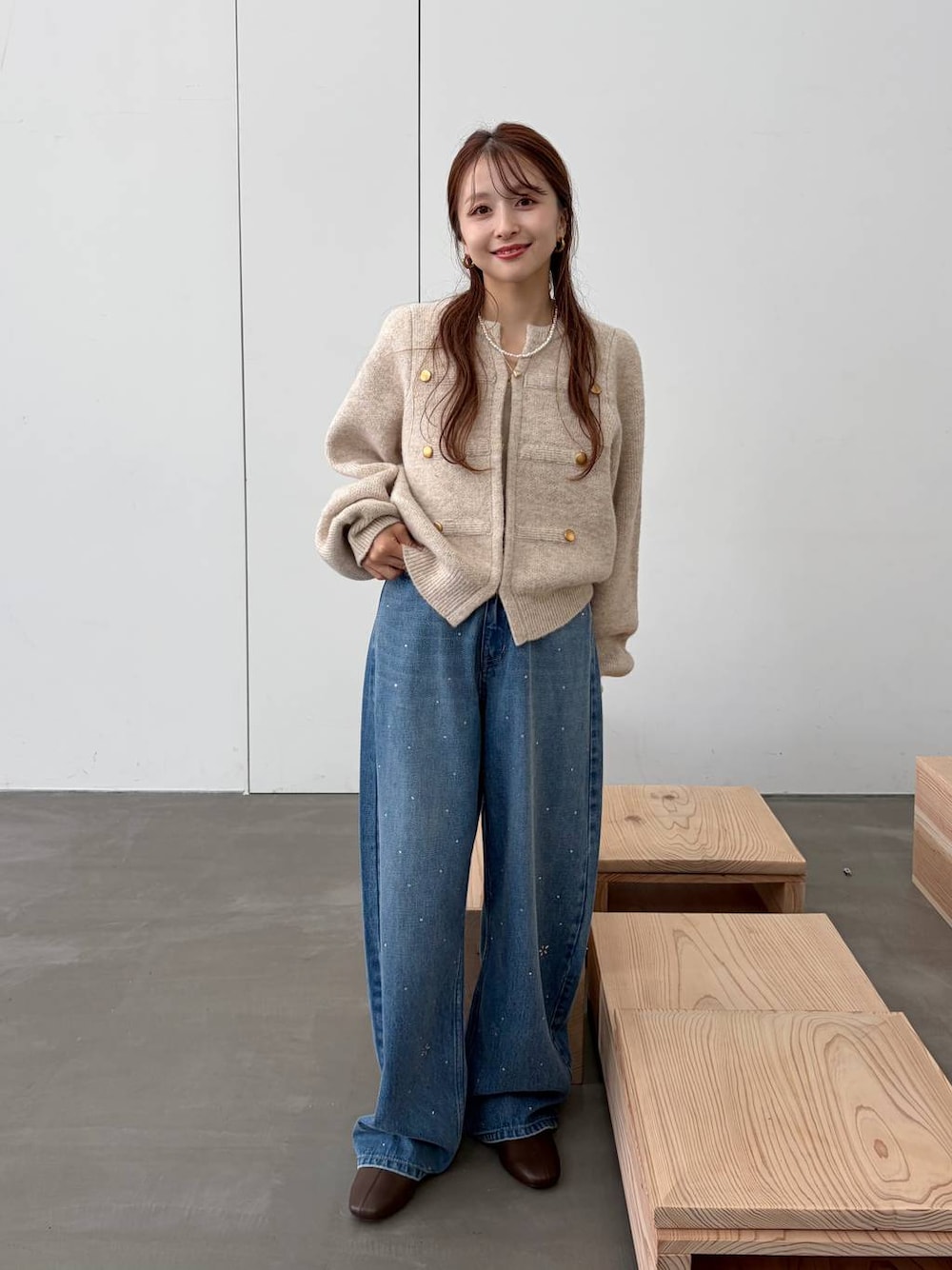 ブラウン系のブーツ、ブルー系のデニムパンツ、ホワイト系のノーカラージャケットを着用したレディースの秋コーディネートの1枚目の写真