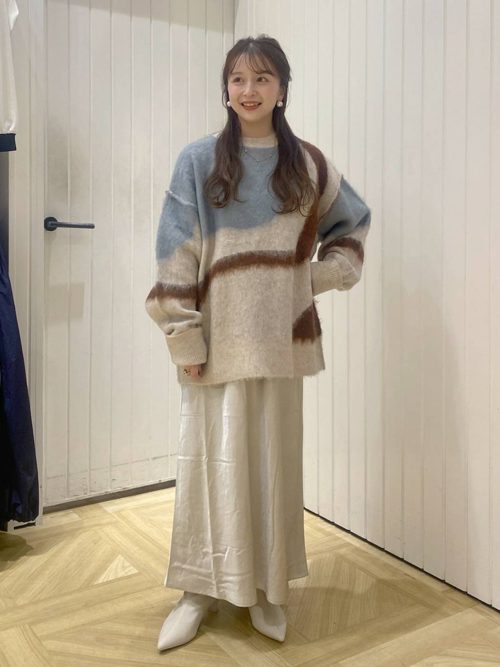 ホワイト系のスカート、ホワイト系のブーツ、ホワイト系のニット/セーターを着用したレディースの秋コーディネートの1枚目の写真