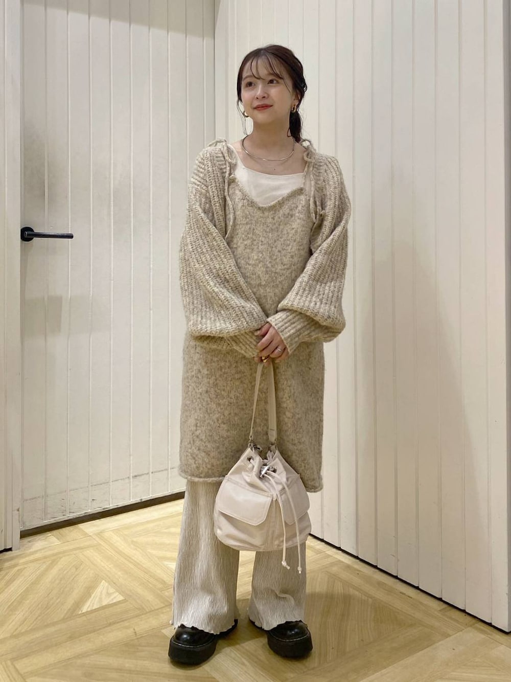 ホワイト系のタンクトップ、ホワイト系のショルダーバッグ、ホワイト系のその他パンツを着用したレディースの秋コーディネートの1枚目の写真