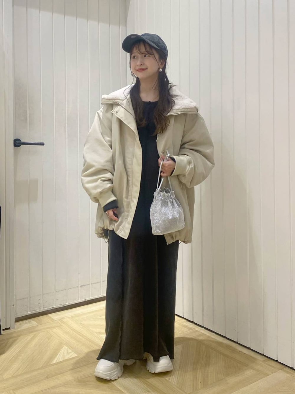 ホワイト系のブルゾン、ホワイト系のスニーカー、シルバー系のショルダーバッグを着用したレディースの秋コーディネートの1枚目の写真