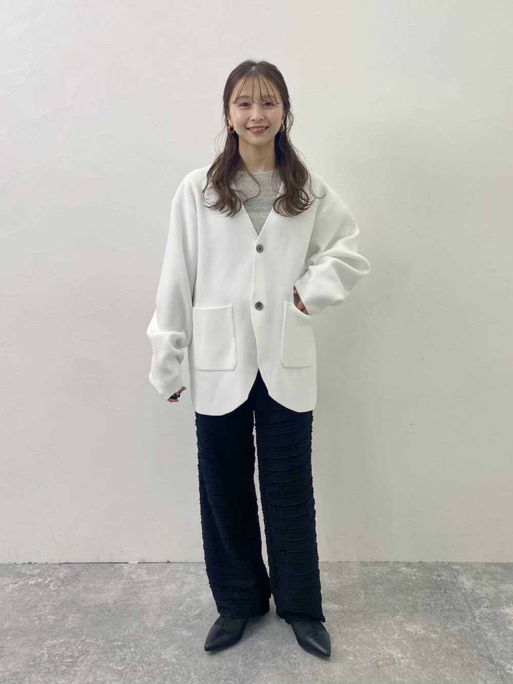 ブラック系のその他パンツ、グレー系のTシャツ/カットソー、ホワイト系のカーディガン/ボレロを着用したレディースの冬コーディネートの1枚目の写真