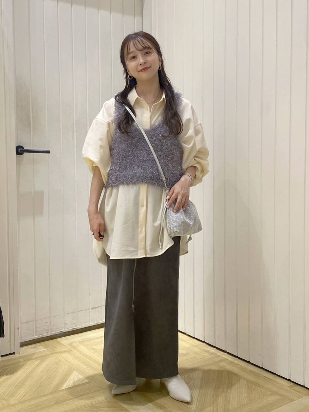 グレー系のキャミソール、シルバー系のショルダーバッグ、ホワイト系のブーツを着用したレディースの秋コーディネートの1枚目の写真