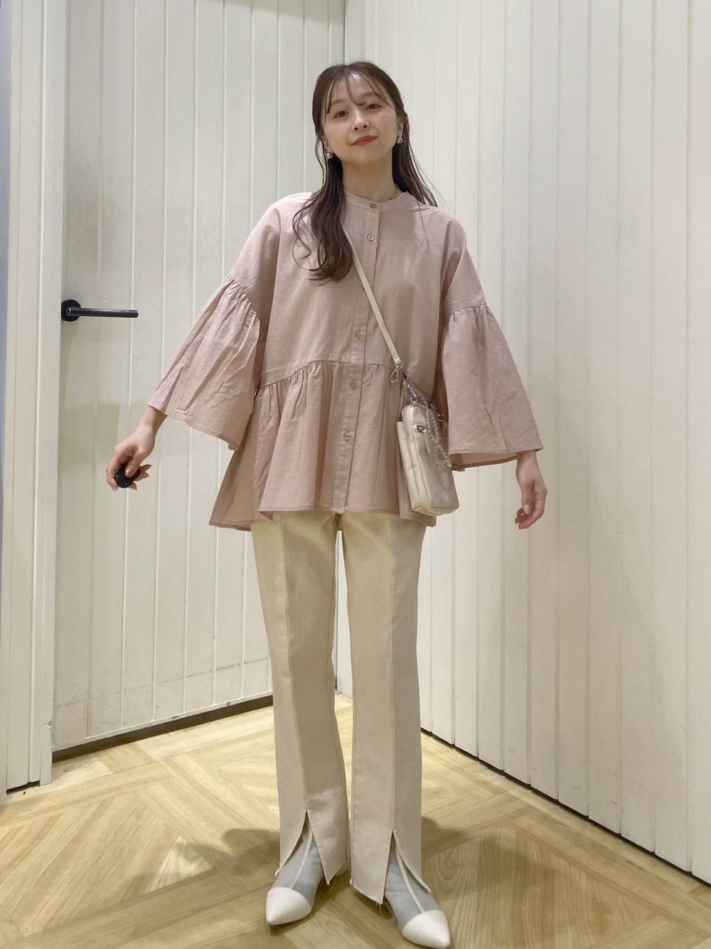 ベージュ系のショルダーバッグ、ホワイト系のブーツ、ピンク系のシャツ/ブラウスを着用したレディースの春コーディネートの1枚目の写真