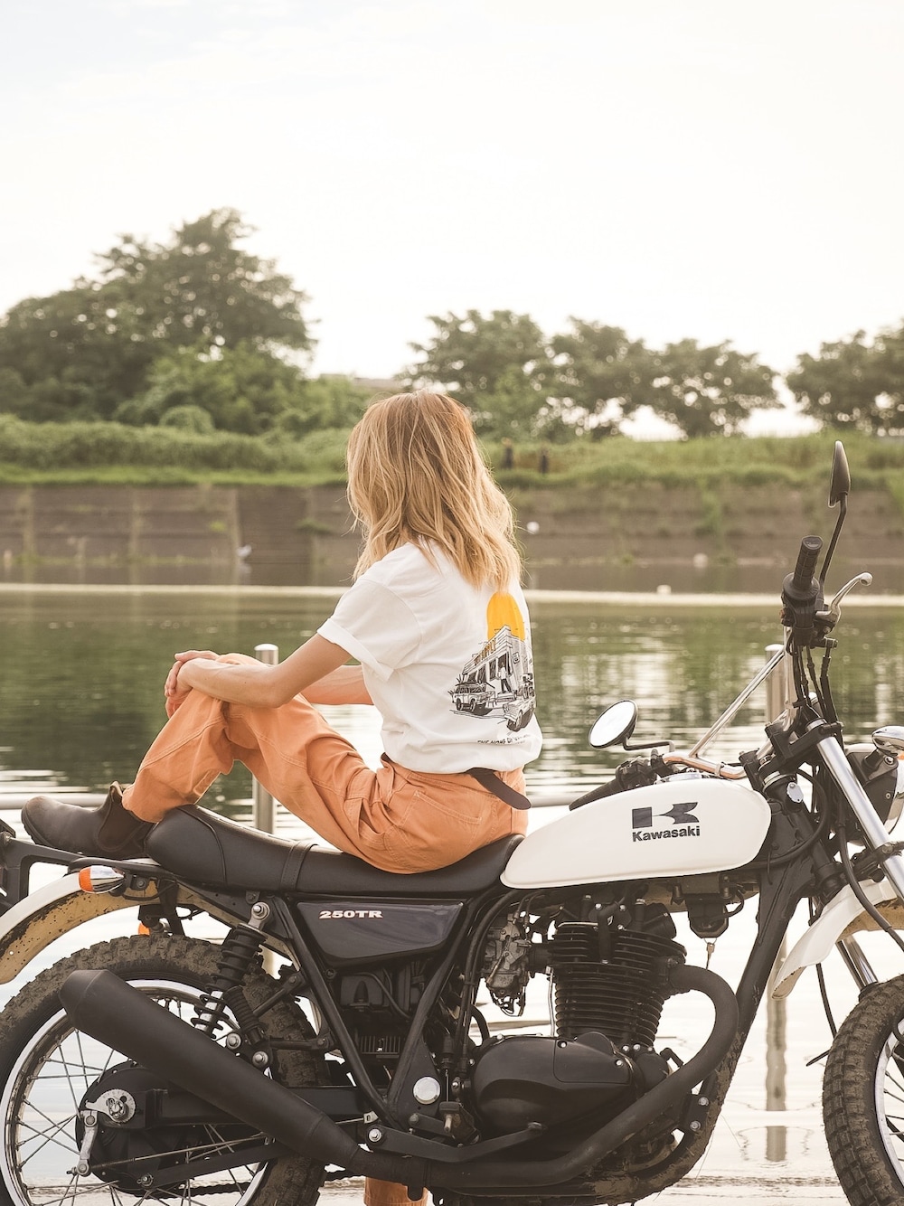 「休日スタイル、夏コーデ、バイクスタイル、ロゴT、白Tシャツ、カラーパンツ、ペインターパンツ、ベイカーパンツ、オレンジ、大人カジュアル、シンプルコーデ、30代コーデ、オトナ女子、ブーツ、カラーコーデ」｜「WEST SUPPLYのアイテム（Tシャツ/カットソー、ホワイト系）」を使った、階上実穂さん（骨格ナチュラル・レディース・158cm）の夏コーディネートの1枚目の写真