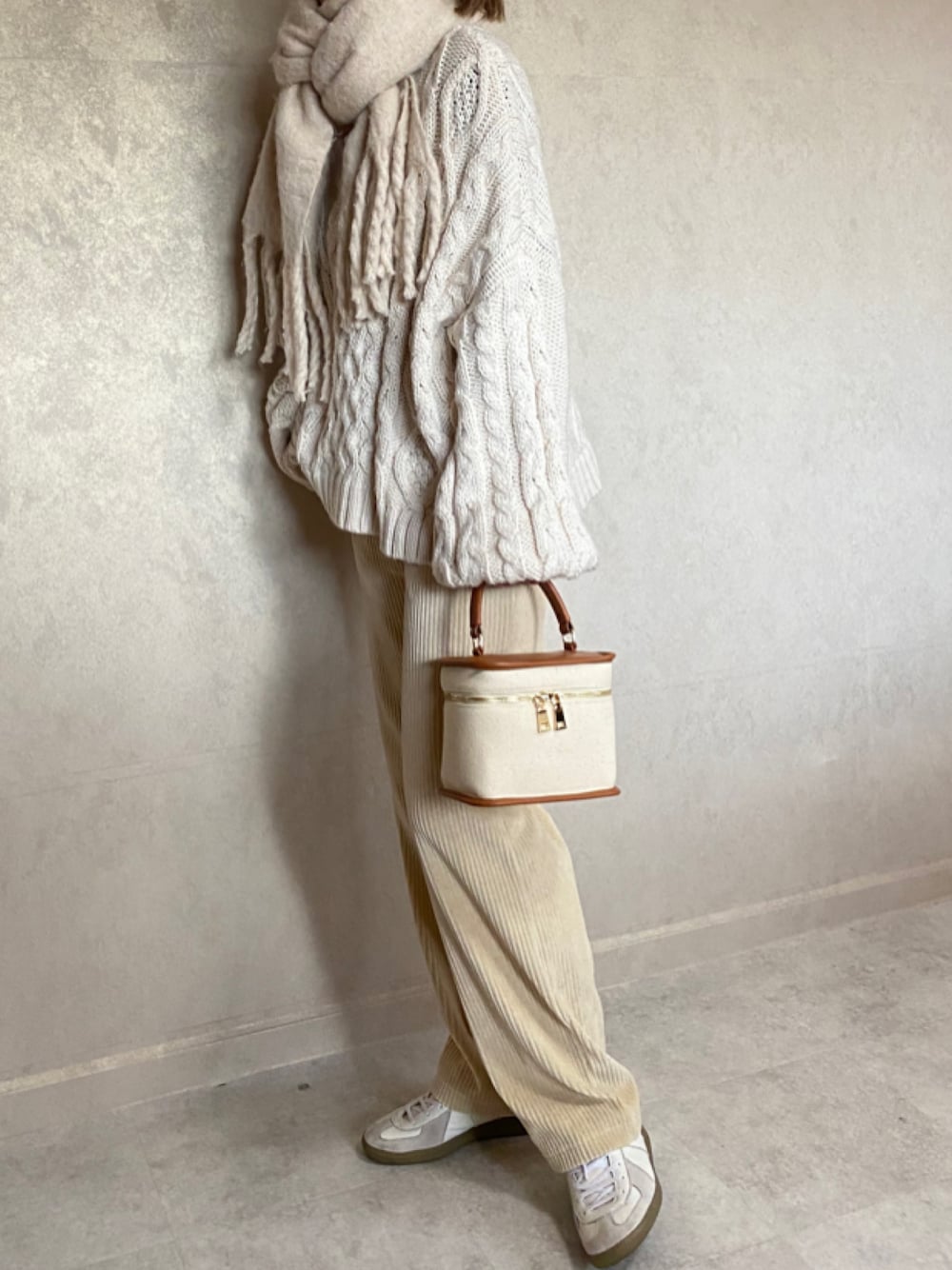 ベージュ系のニット/セーター、ホワイト系のその他パンツ、ホワイト系のスニーカーを着用したレディースの冬コーディネートの1枚目の写真