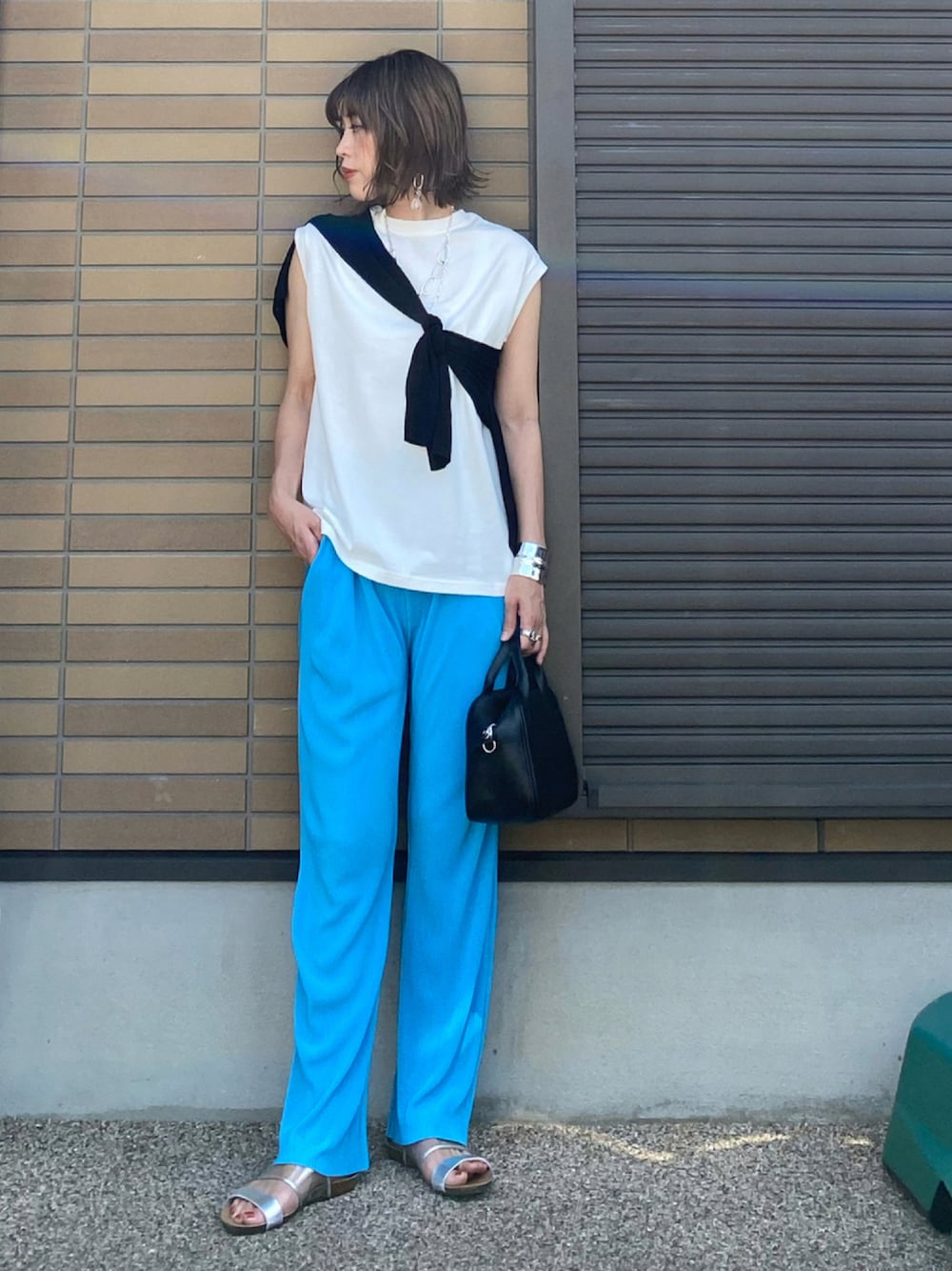 ホワイト系のTシャツ/カットソー、イエロー系のその他パンツ、ブラック系のハンドバッグを着用したレディースの夏コーディネートの1枚目の写真