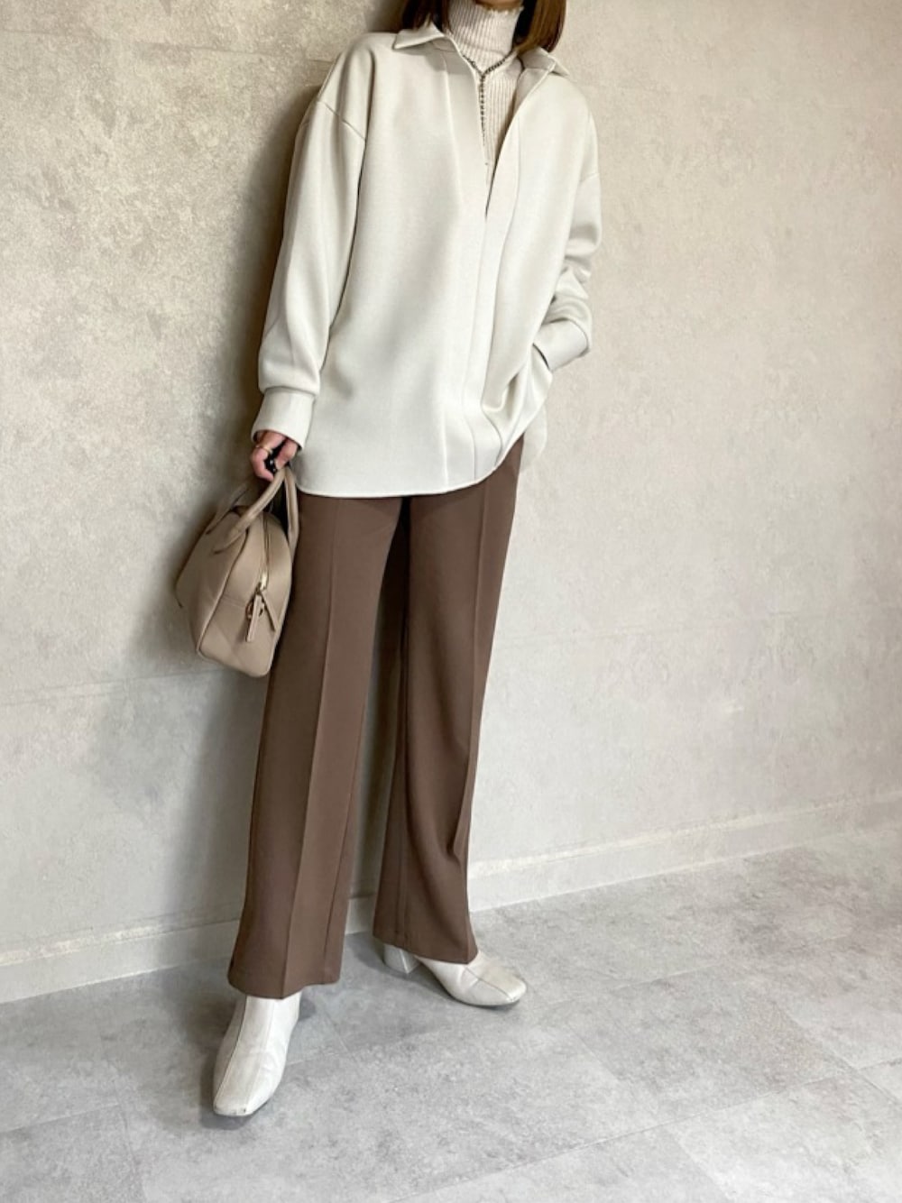 ホワイト系のシャツ/ブラウス、ブラウン系のスラックス、ベージュ系のトートバッグを着用したレディースの冬コーディネートの1枚目の写真