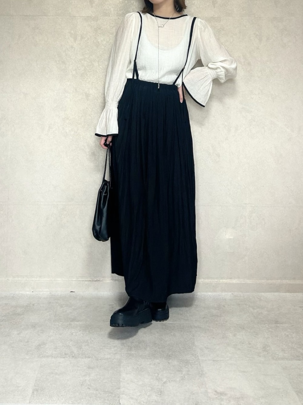 ホワイト系のシャツ/ブラウス、ブラック系のスカート、ブラック系のショルダーバッグを着用したレディースの春コーディネートの1枚目の写真