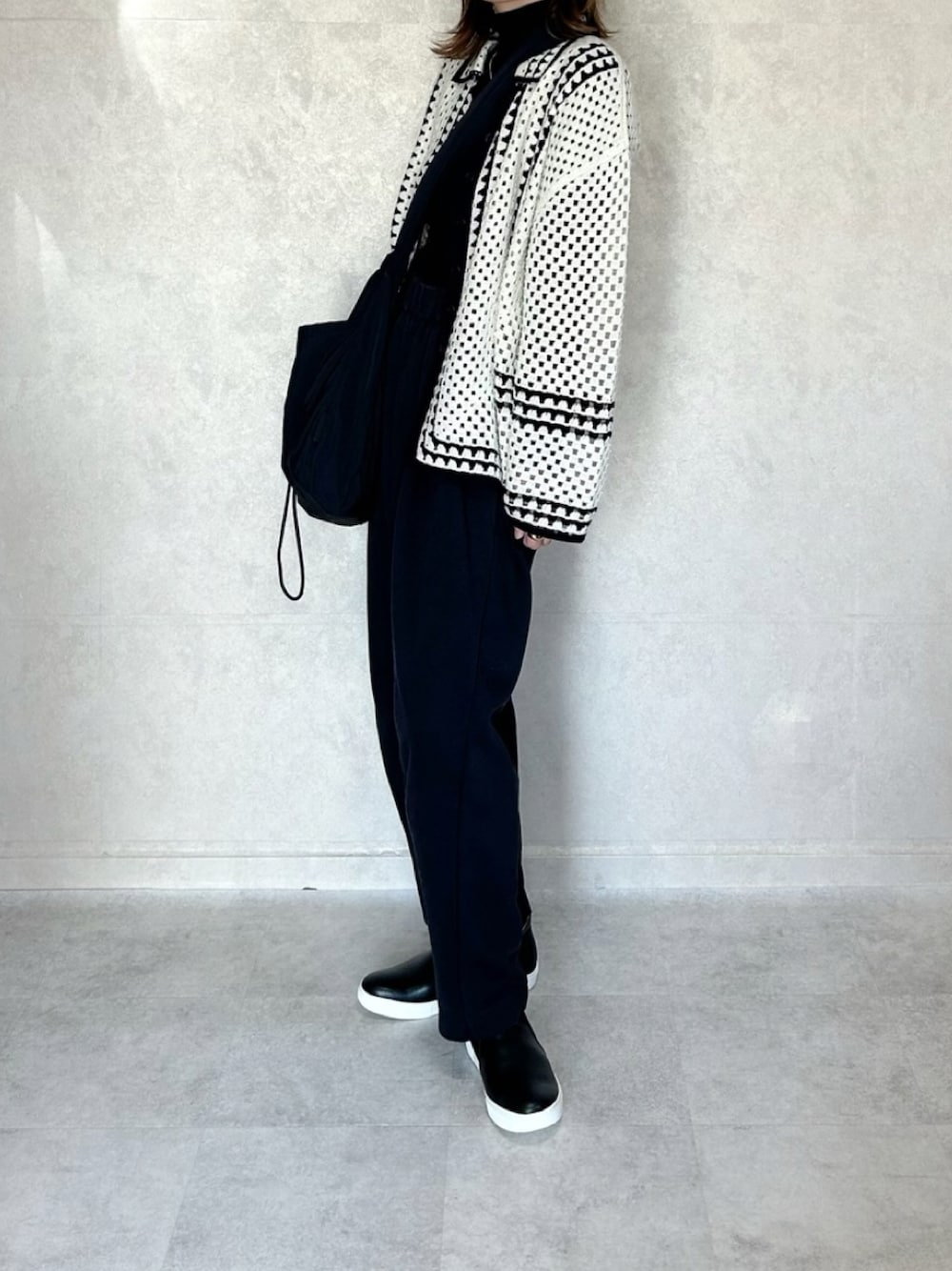 ホワイト系のカーディガン/ボレロ、ブラック系のボディバッグ/ウエストポーチを着用したレディースの秋コーディネートの1枚目の写真