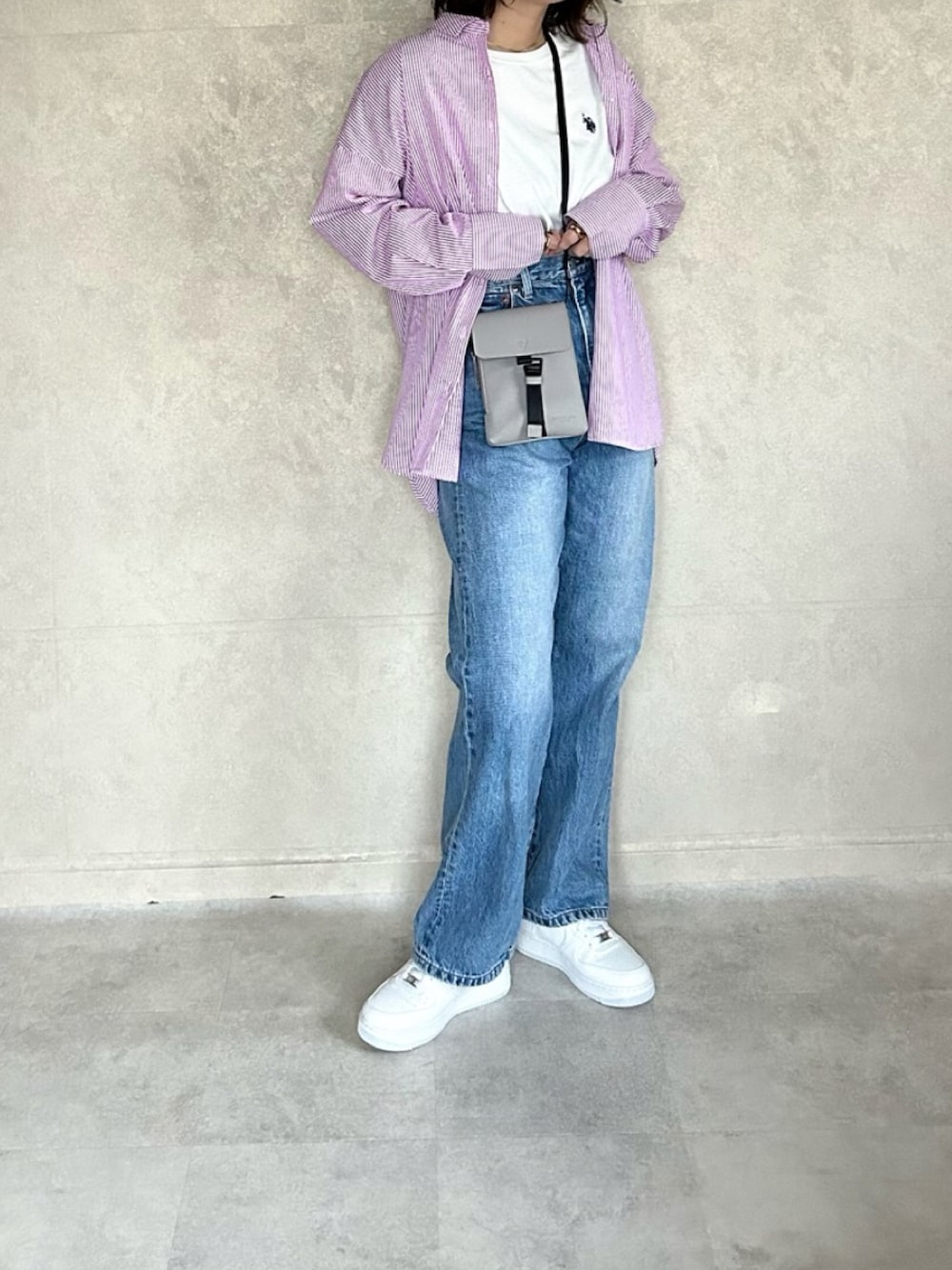 ピンク系のシャツ/ブラウス、グレー系のバッグ、ホワイト系のTシャツ/カットソーを着用したレディースの春コーディネートの1枚目の写真