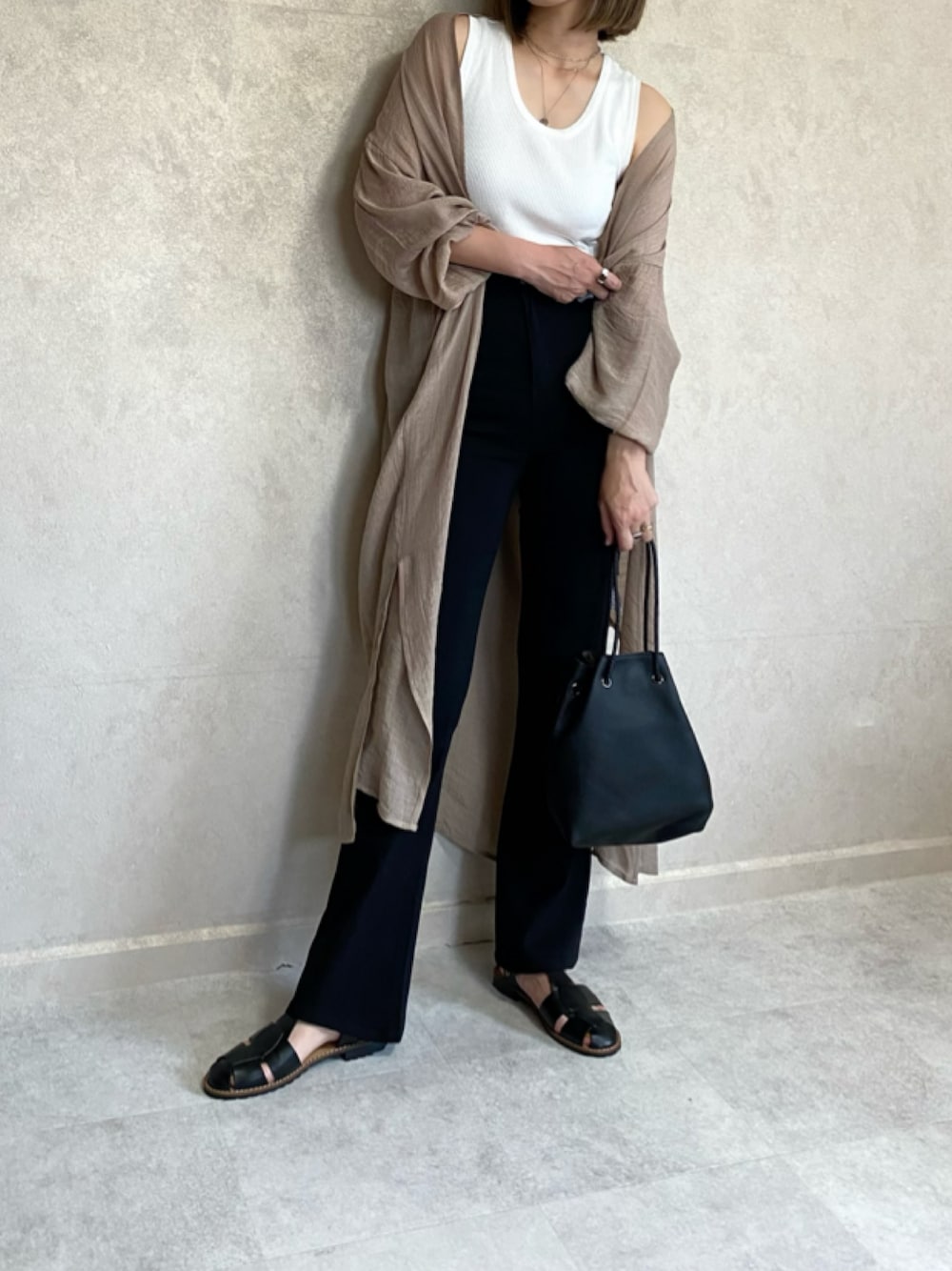 ベージュ系のカーディガン/ボレロ、ホワイト系のタンクトップ、ブラック系のその他パンツを着用したレディースの春コーディネートの1枚目の写真