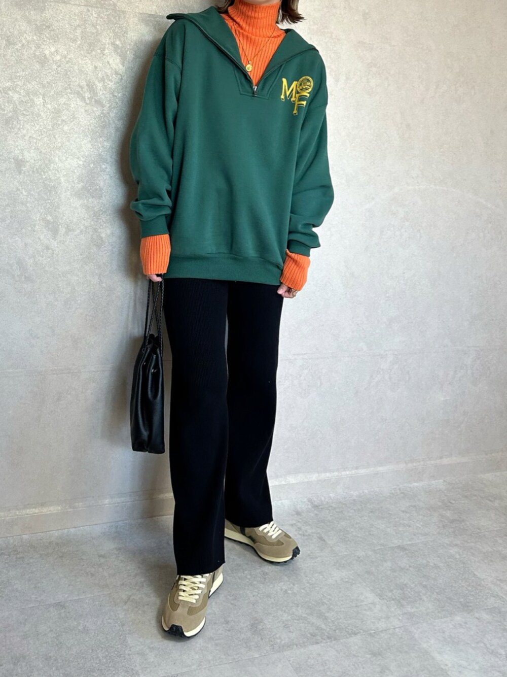 グリーン系のスウェット、オレンジ系のニット/セーター、ブラック系のショルダーバッグを着用したレディースの秋コーディネートの1枚目の写真