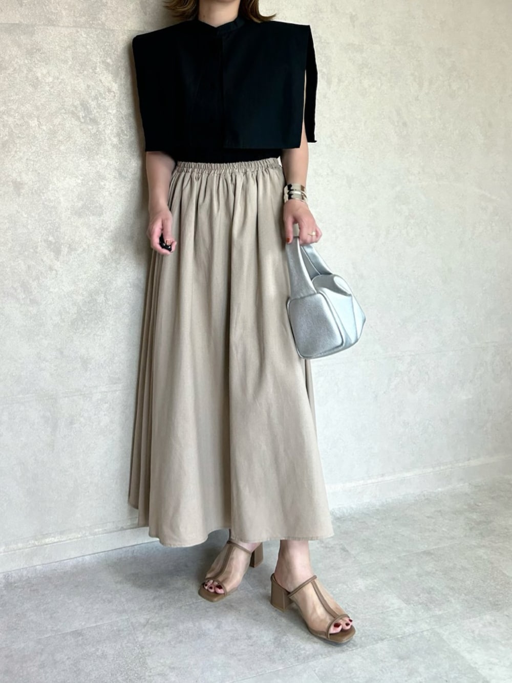 ブラック系のシャツ/ブラウス、シルバー系のボストンバッグ、ベージュ系のサンダルを着用したレディースの秋コーディネートの1枚目の写真