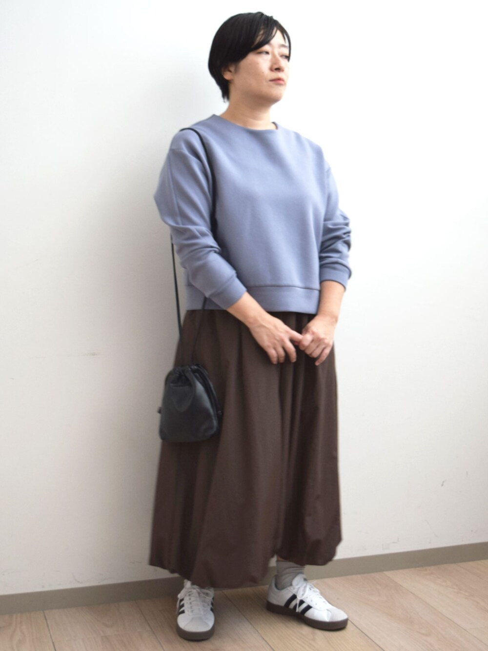 ブラウン系のスカート、ブルー系のスウェットを着用したレディースの秋コーディネートの1枚目の写真