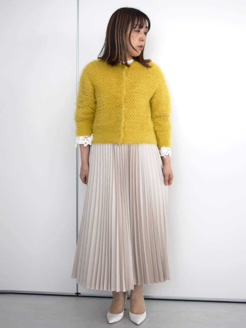 ベージュ系のスカート、ホワイト系のシャツ/ブラウス、イエロー系のカーディガン/ボレロを着用したレディースの秋コーディネートの1枚目の写真