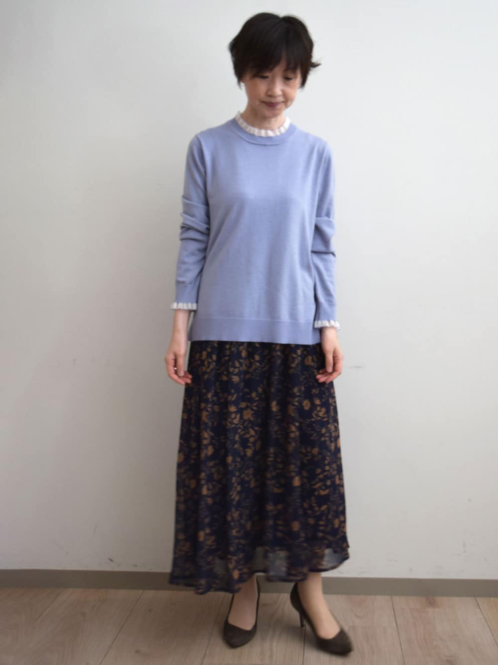 ブルー系のスカート、パープル系のニット/セーターを着用したレディースの秋コーディネートの1枚目の写真