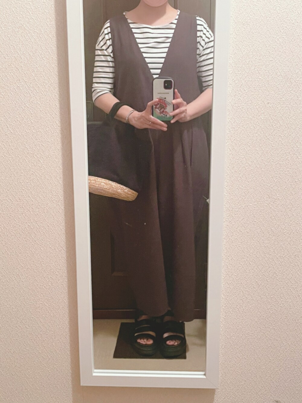 オレンジ系のTシャツ/カットソー、グレー系のサロペット/オーバーオール、ブラック系のサンダルを着用したレディースの夏コーディネートの1枚目の写真