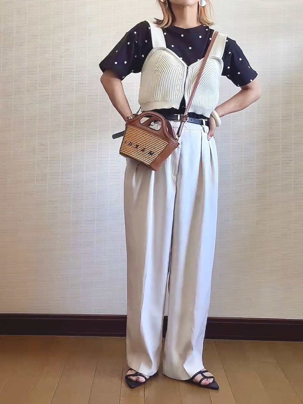 ブラック系のTシャツ/カットソー、ホワイト系のニット/セーター、ベージュ系のショルダーバッグを着用したレディースの夏コーディネートの1枚目の写真