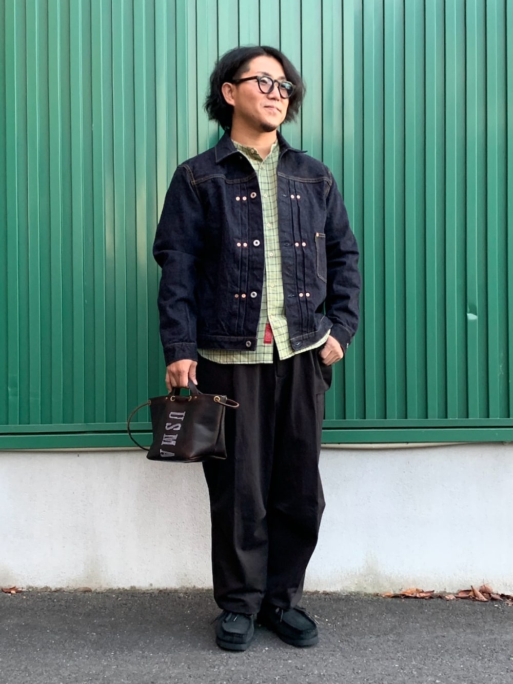 ブルー系のデニムジャケット、グリーン系のシャツ/ブラウス、ブラウン系のトートバッグを着用したメンズの秋コーディネートの1枚目の写真