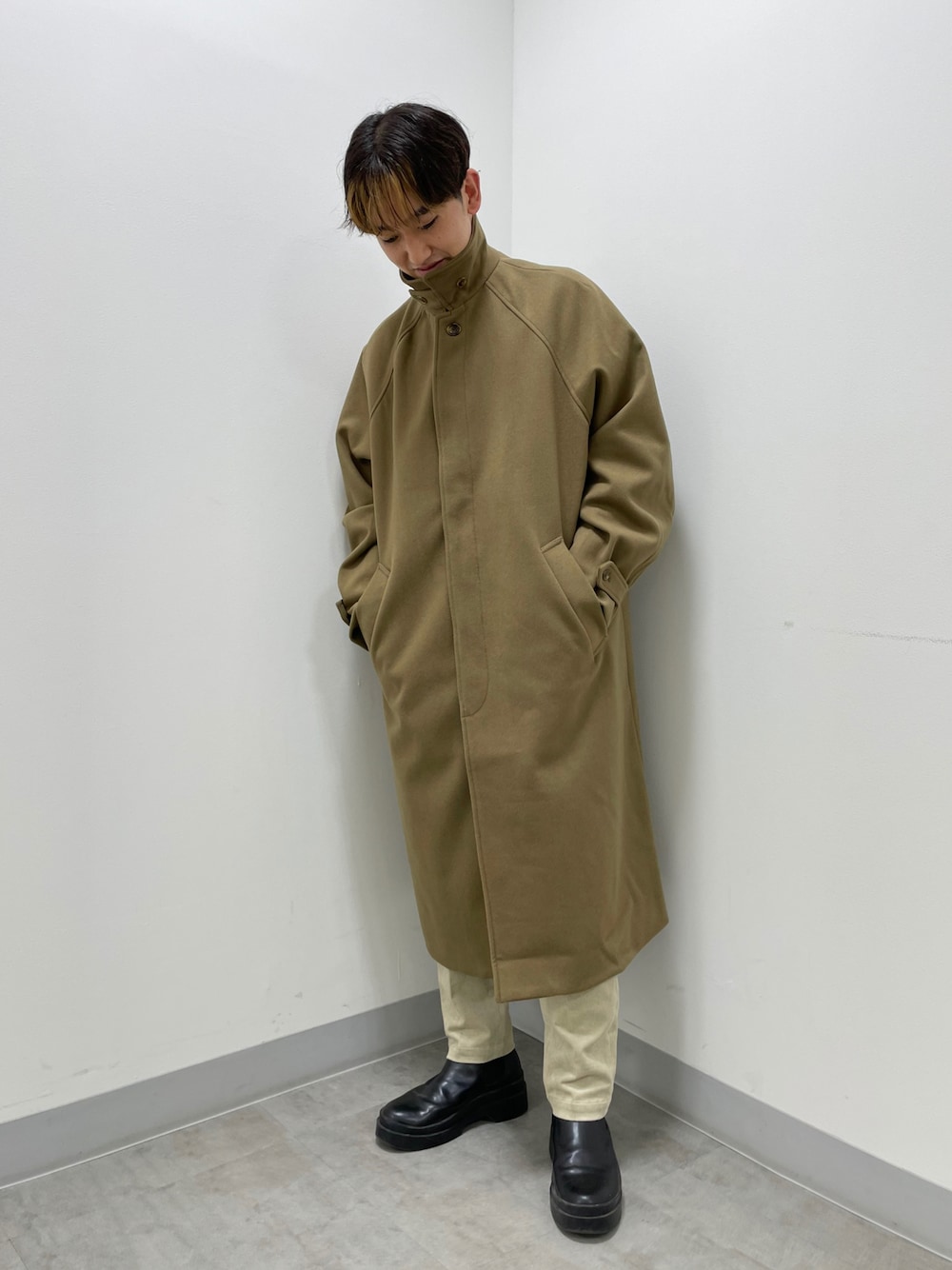 ベージュ系のステンカラーコート、グレー系のその他パンツを着用したメンズの秋コーディネートの1枚目の写真