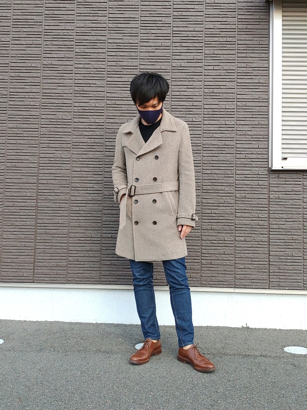 ベージュ系のジャケット/アウター、ブラック系のニット/セーター、ブルー系のデニムパンツを着用したメンズの冬コーディネートの2枚目の写真