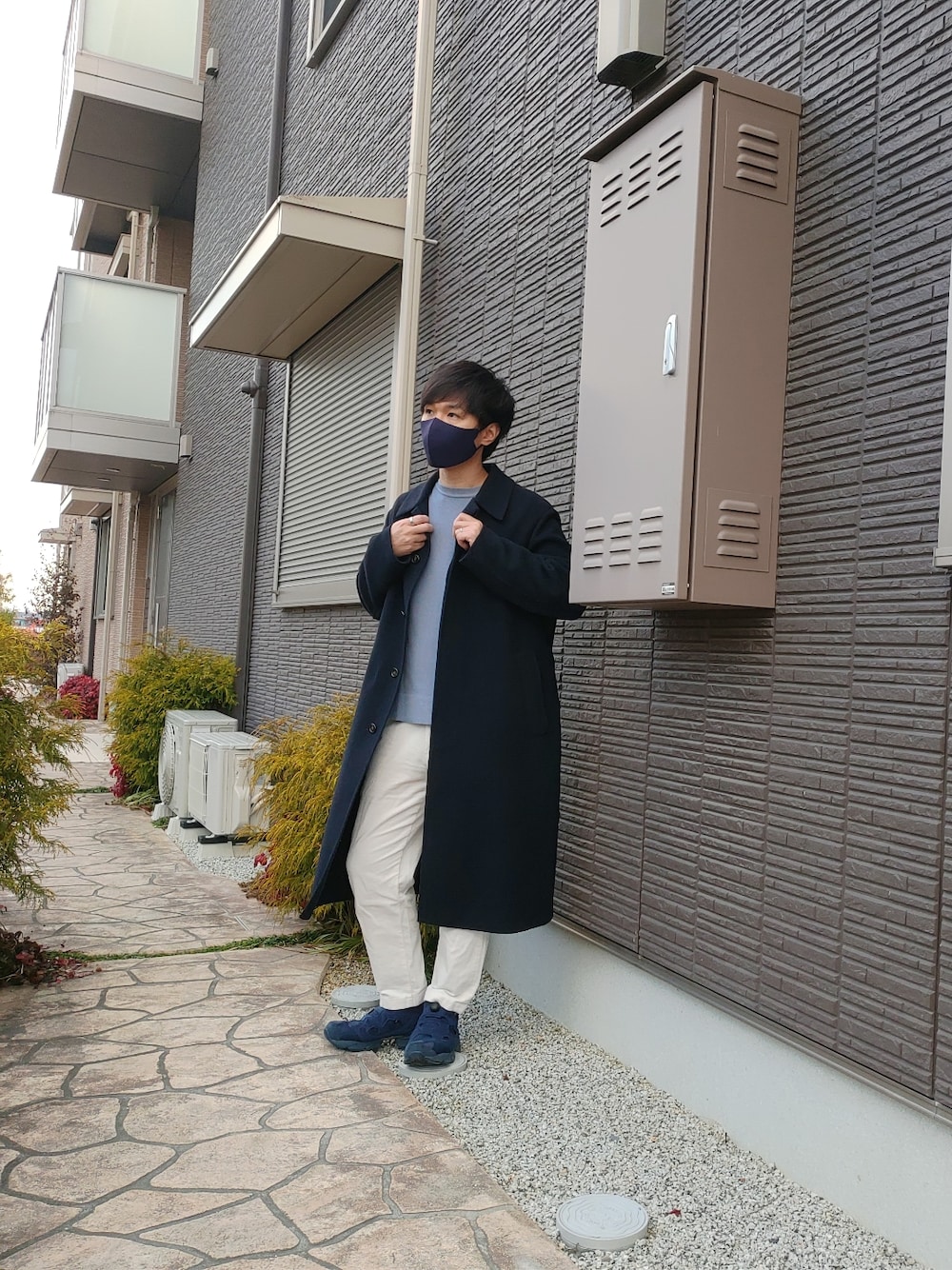 ブルー系のステンカラーコート、ブルー系のニット/セーター、ホワイト系のその他パンツを着用したメンズの冬コーディネートの2枚目の写真