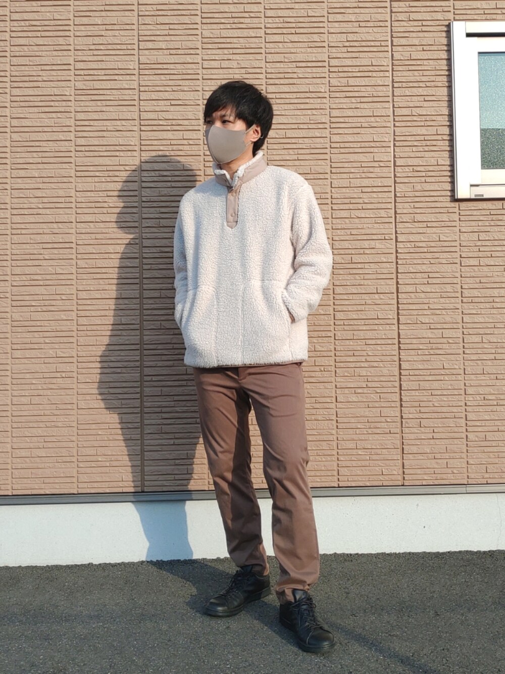 ベージュ系のブルゾン、ブラウン系のスラックス、ブラック系のスニーカーを着用したメンズの冬コーディネートの2枚目の写真