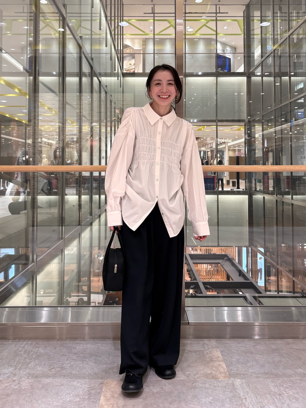 ホワイト系のシャツ/ブラウス、ブラック系のボストンバッグを着用したレディースの冬コーディネートの1枚目の写真