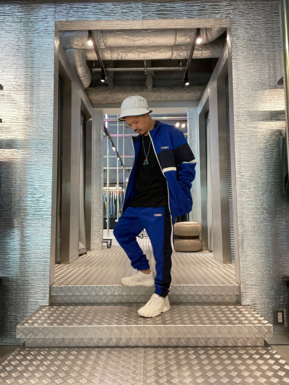 ブルー系のパンツ、ホワイト系のスニーカー、ブルー系のジャージを着用したメンズの秋コーディネートの1枚目の写真