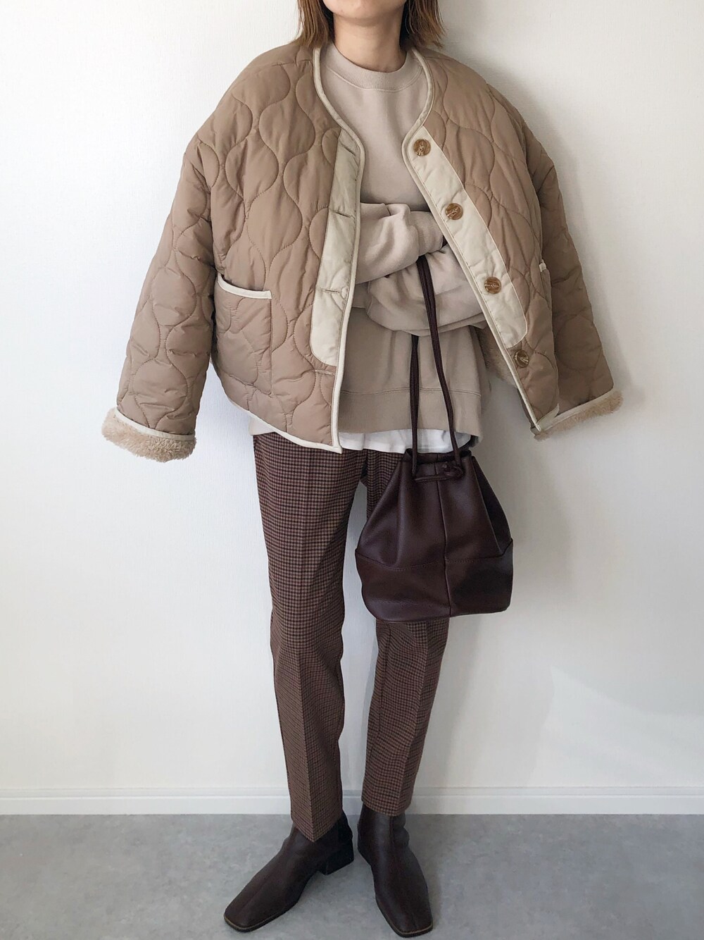 ベージュ系のブルゾン、ベージュ系のスウェット、ホワイト系のTシャツ/カットソーを着用したレディースの冬コーディネートの1枚目の写真