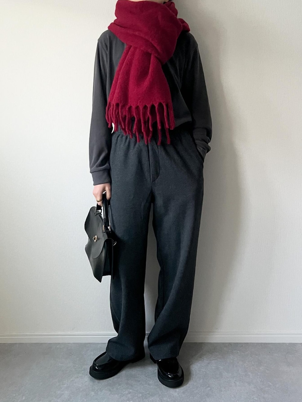 グレー系のトップス、グレー系のパンツ、ブラック系のショルダーバッグを着用したレディースの冬コーディネートの1枚目の写真