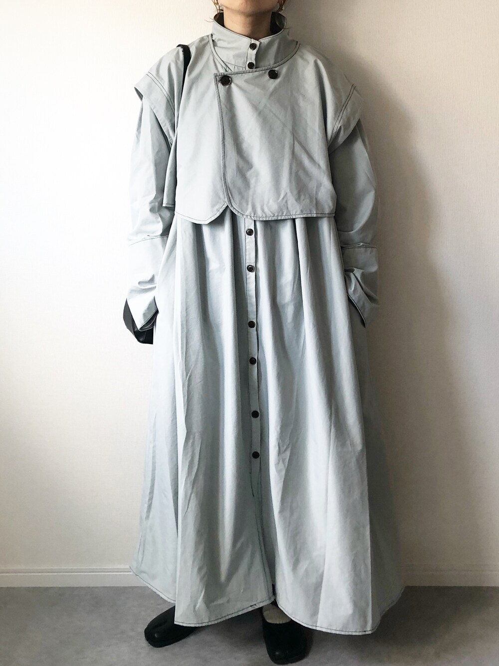 グレー系のノーカラーコート、ブラック系のショルダーバッグ、ブラック系のバレエシューズを着用したレディースの春コーディネートの1枚目の写真