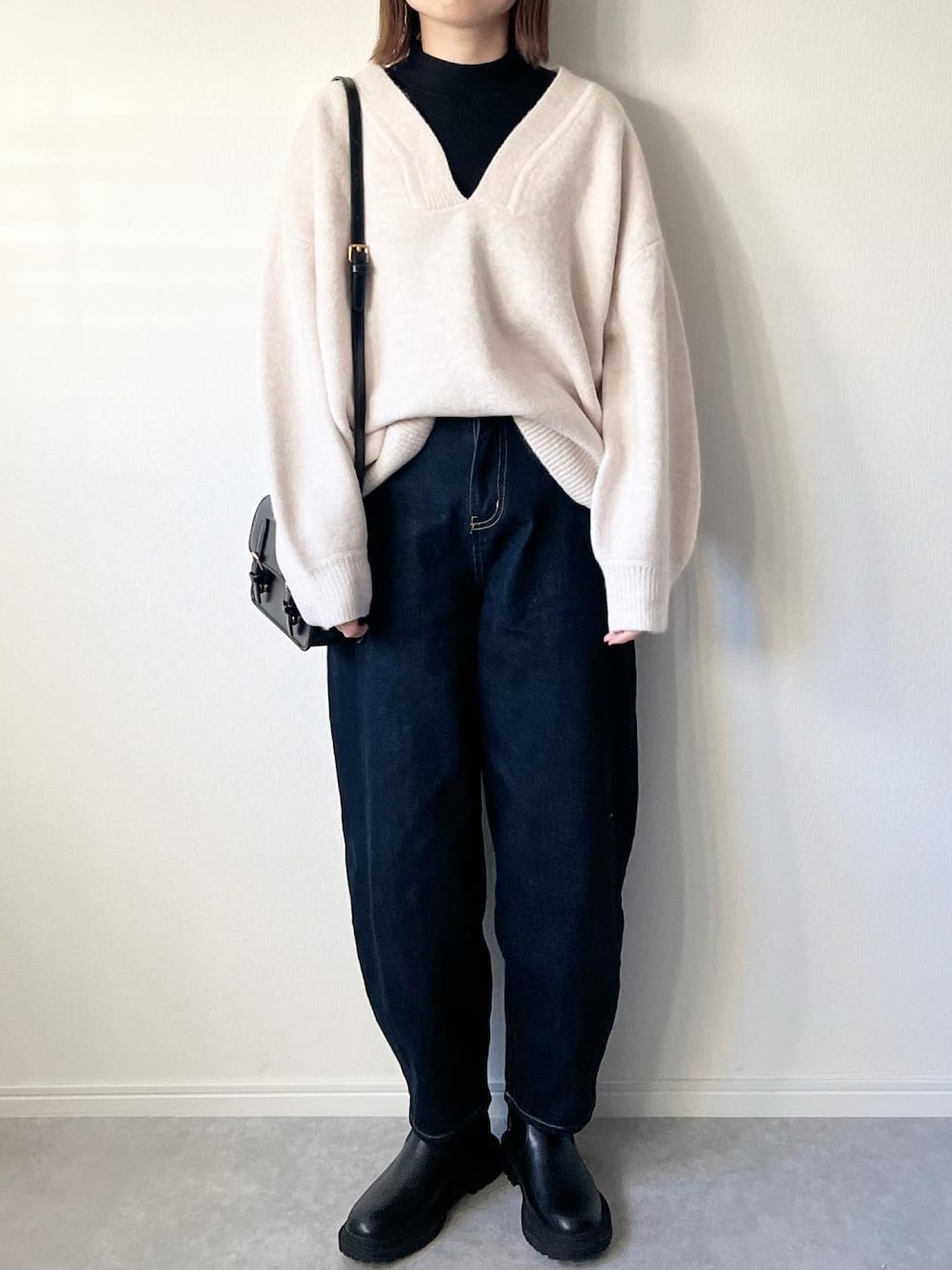 ベージュ系のニット/セーター、ブルー系のデニムパンツ、ブラック系のブーツを着用したレディースの冬コーディネートの1枚目の写真