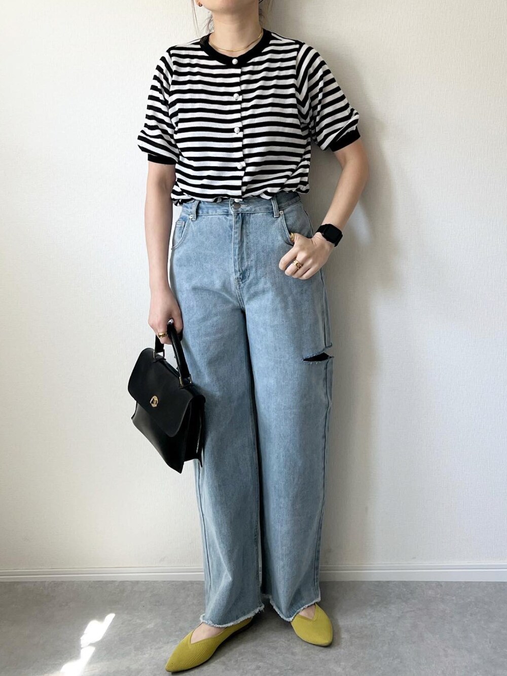 ブルー系のデニムパンツ、ブラック系のショルダーバッグ、イエロー系のバレエシューズを着用したレディースの春コーディネートの1枚目の写真