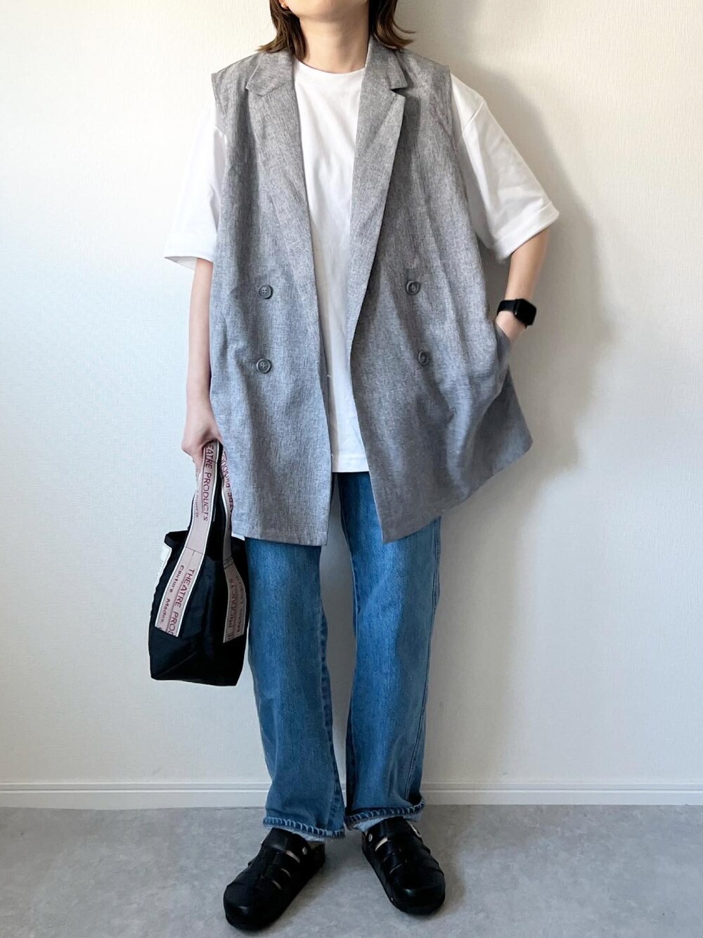 グレー系のベスト、ホワイト系のTシャツ/カットソー、ブラック系のショルダーバッグを着用したレディースの春コーディネートの1枚目の写真